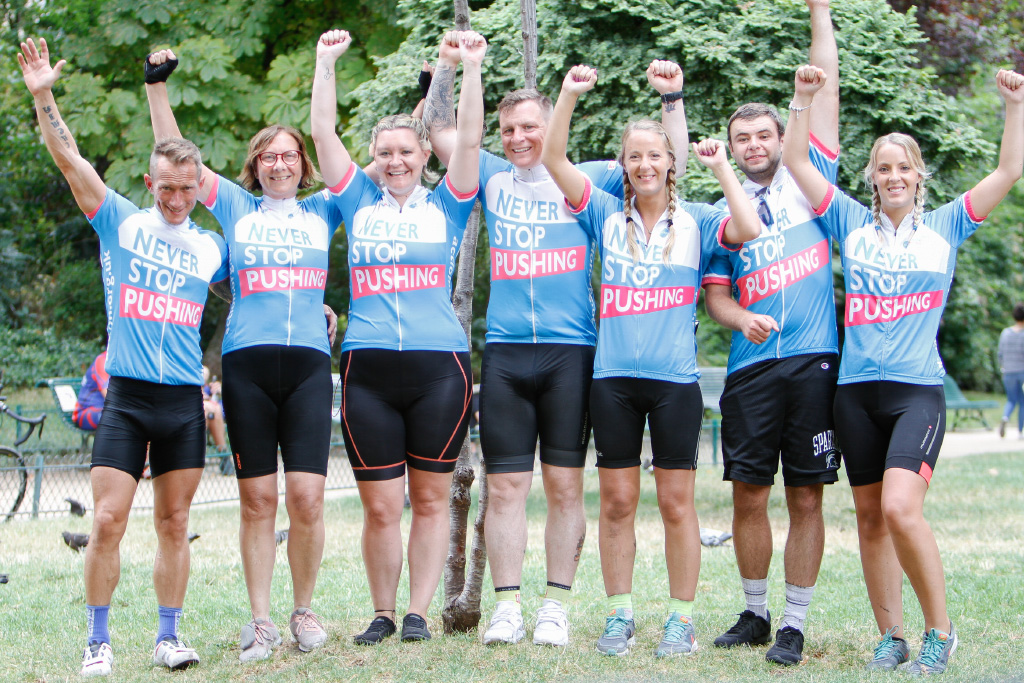group of seven cyclists with arms aloft