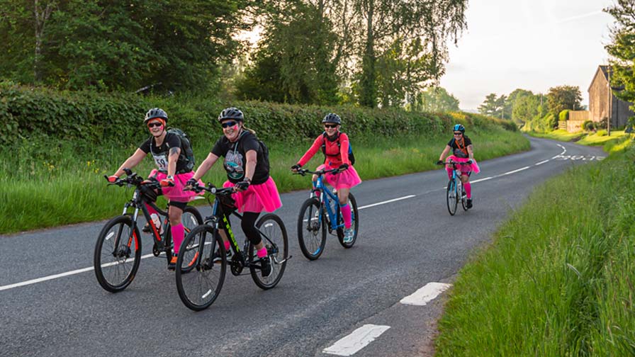 team of cyclists in pink tu-tus