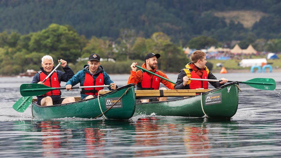 team paddling in canoes