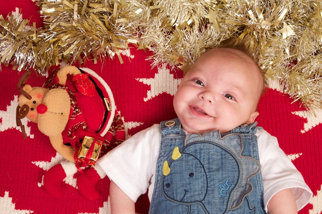Smiling baby with reindeer toy