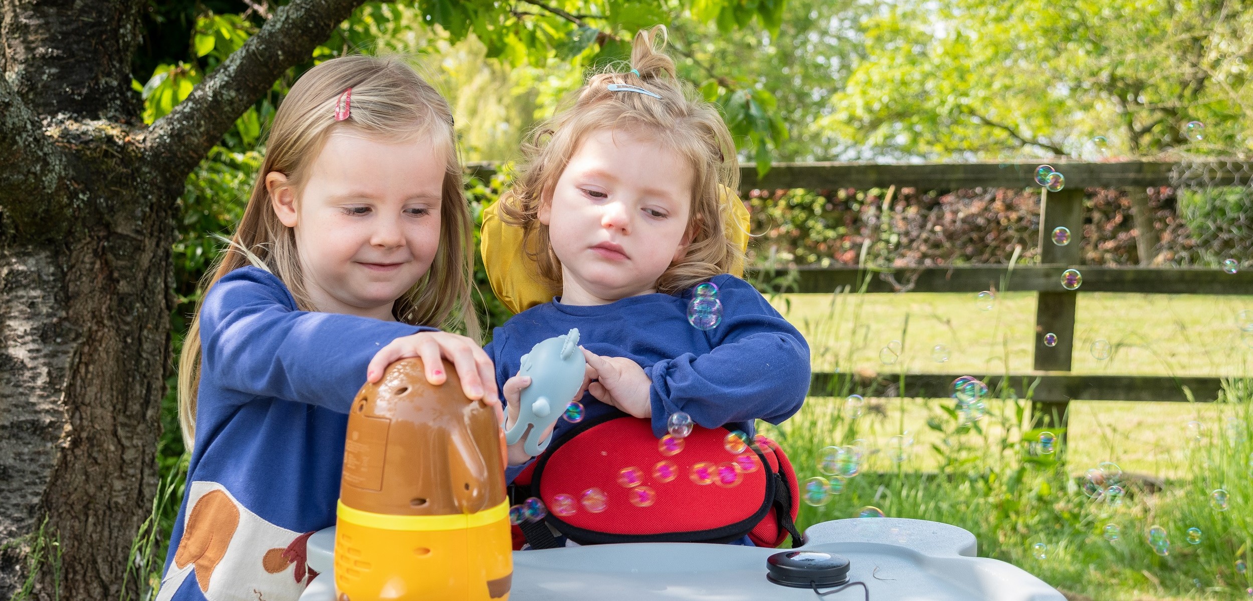 Emmy, who has very rare Vici syndrome, and her sister Tilly, out in the garden.