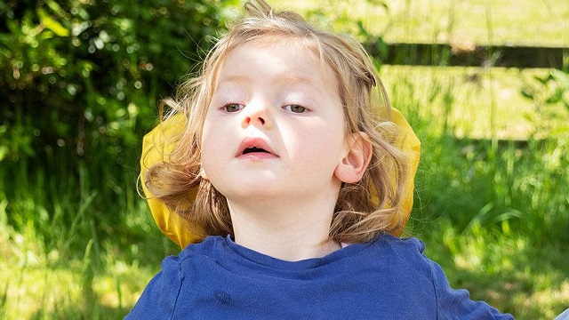 Emmy, who has very rare Vici syndrome, out in the garden.