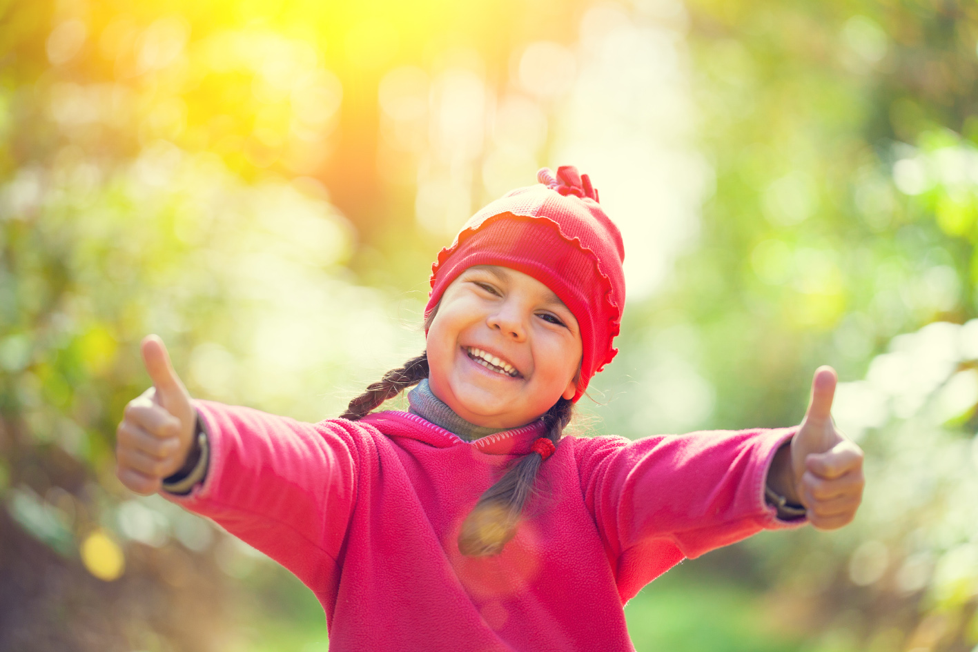 Smiling child giving a thumbs up 