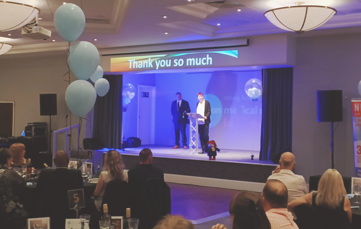 Action chief executive Julie Buckler on stage with a toy Paddington bear during the Peterborough thank you dinner.