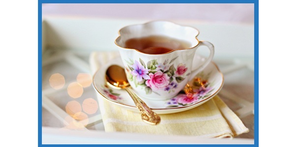 A cup of tea with saucer and spoon