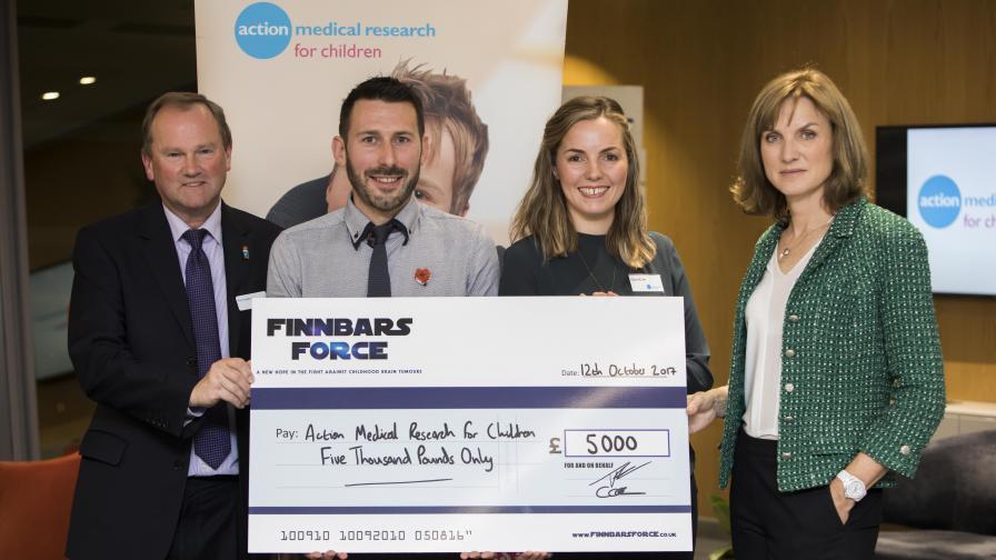 A trust partner presenting Action with a large cheque