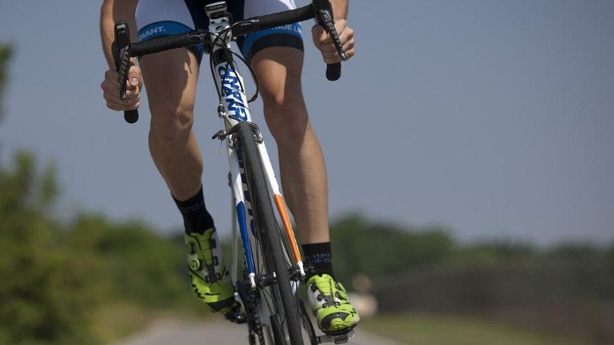lone cyclist riding along a road