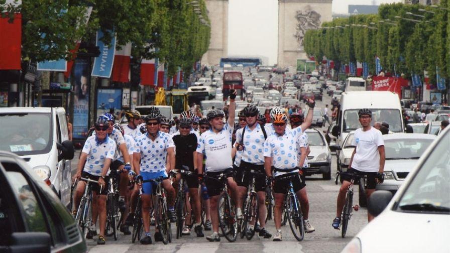 pete in black riding along the champs elysees