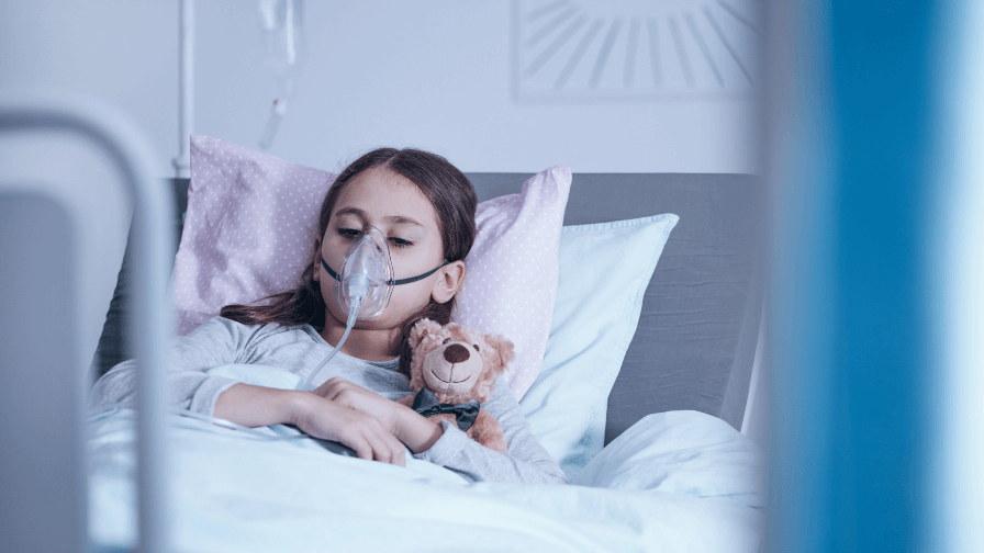 Child in hospital bed wearing oxygen mask