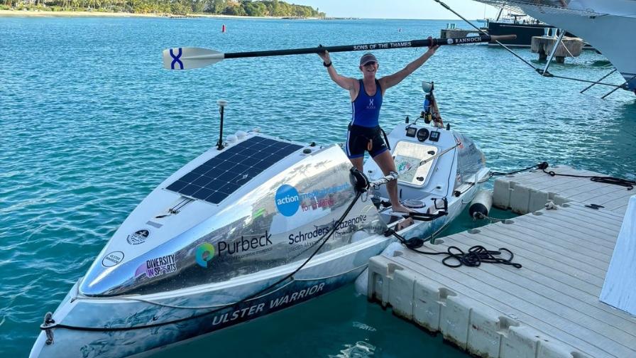 Linda at finish, holding an oar above her head