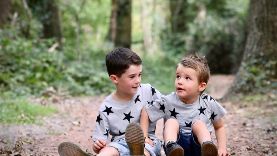 Mylo with his older brother, sat in woodland.