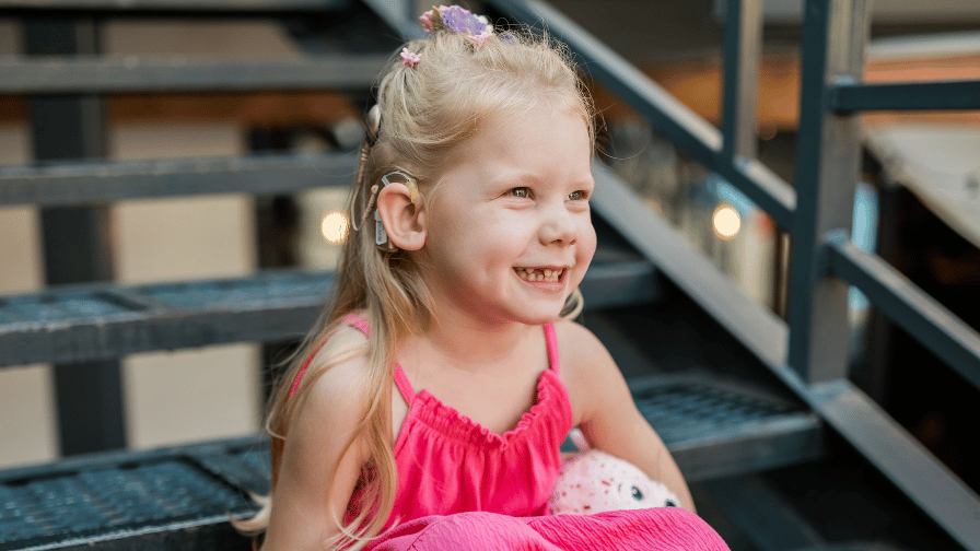 Young girl wearing hearing aids and cochlear implant