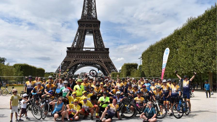 Large group of cyclists celebrating in front of the Eiffel Tower