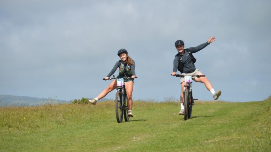Two cyclists celebrating on a grass path