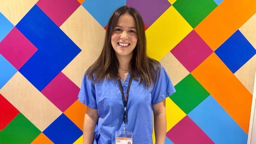 Image of Dr Eva in front of colourful backdrop