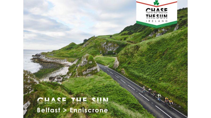 group of cyclists on chase the sun riding along a rugged coastline road with vibrant lush green hillside
