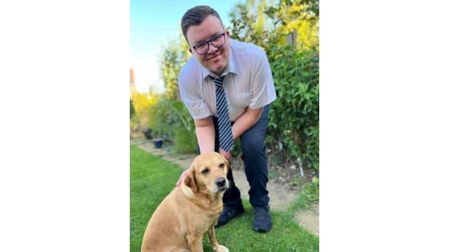 Image of Luke in his garden playing with his dog