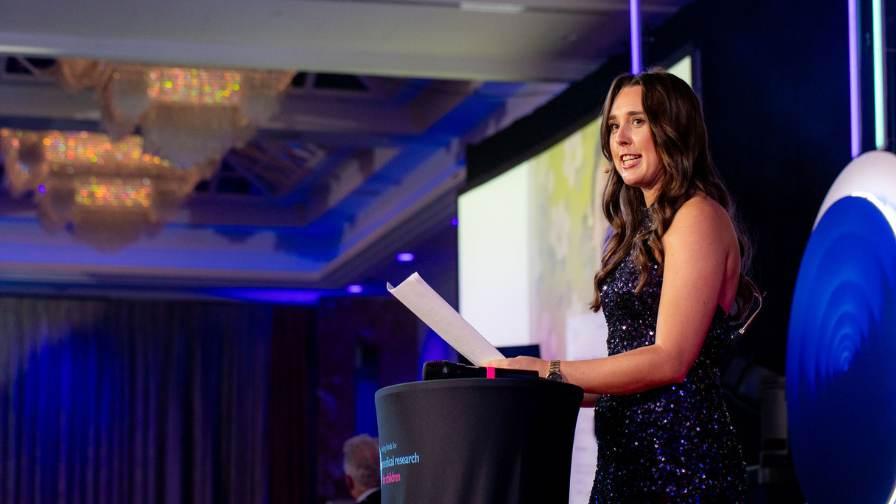 Image of Hannah Walker on stage delivering keynote speech