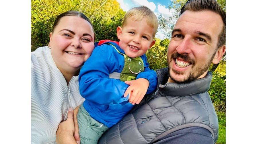 Image of Barnaby smiling with his parents