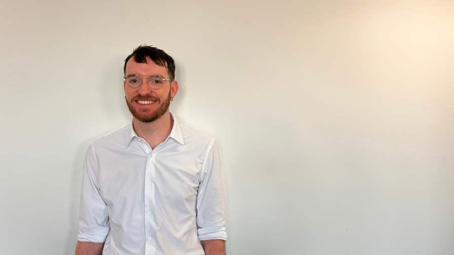 Image of Dr Michael Wilkinson standing in front of wall