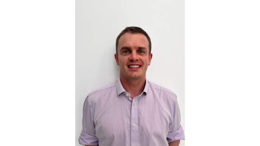 Dr Robert Legg smiling in front of white backdrop