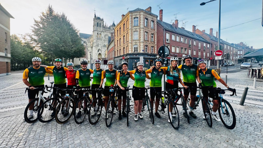 A line up of riders on their bikes but all facing the camera in a chic French street