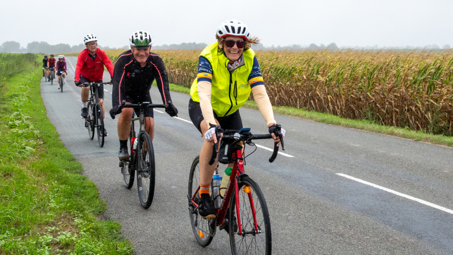 Smiling line of riders cycling along a French country road