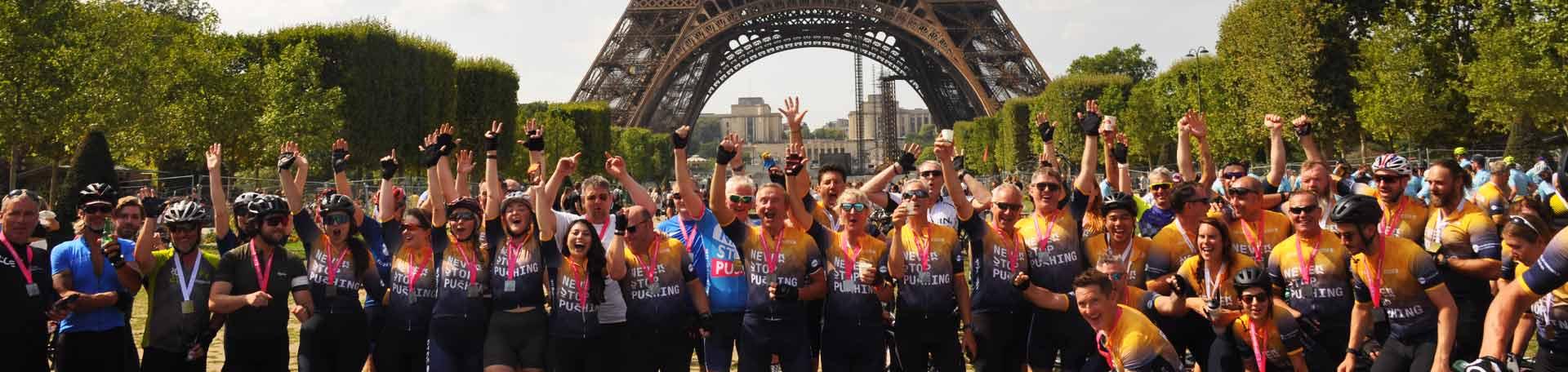 riders celebrate in front of eiffel tower