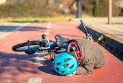 Child laying on the ground having fallen off their bike
