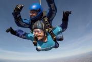 An Action supporter strapped to an instructor during a duo skydive