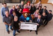 Company members holding a large cheque for Action