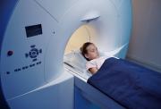 Young girl laying down, about to enter an MRI scanner.