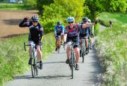 group of cyclists riding along country lane
