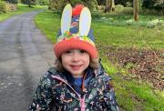 Eva, a three-year-old girl, wearing an Easter hat