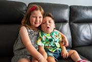 Paddy and his sister hugging on a sofa