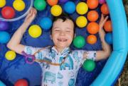 Image of Mylo smiling in a paddling pool