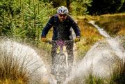 cyclist going through water on a gravel track