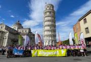 Image of cyclists in front of the tower of Pisa