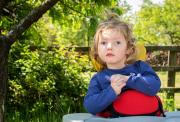 Emmy in a highchair trees and fields in the background