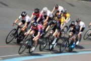 A group of cyclists racing around a Velodrom track