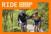 Two wriders cycling on a country road with thick forrests with side of the road