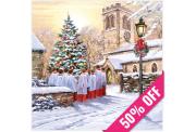 A choir in red and white robes sings around a snowy Christmas tree outside a church at sunset, surrounded by festive winter decor. A 50% off ribbon crosses a corner