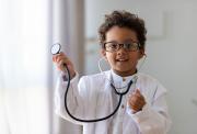 A young boy wearing glasses and a doctor
