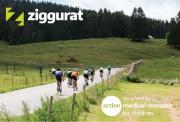 Image of cyclists on a road in countryside surrounded by green hills and trees