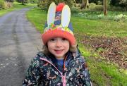 Eva, a three-year-old girl, wearing an Easter hat