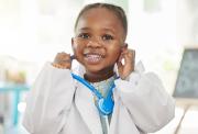Smiling young child wearing a doctor