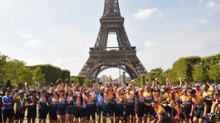 riders celebrate in front of eiffel tower