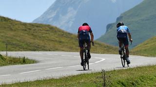 two cyclists riding in the mountains