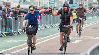 two riders cross the finish line on the london to brighton bike ride