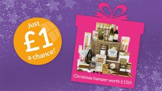 A purple background with stars featuring a £1 raffle offer on the left and a Christmas hamper worth £150 in a pink gift box on the right